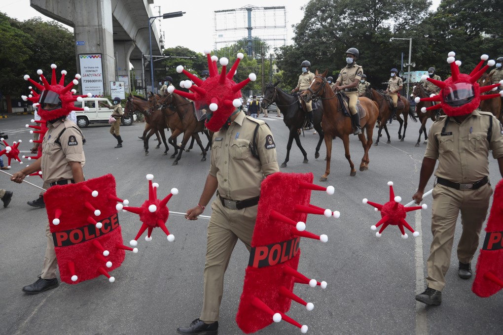 Indian police officers walk wearing virus-themed helmet in Hyderabad. Photo: AP