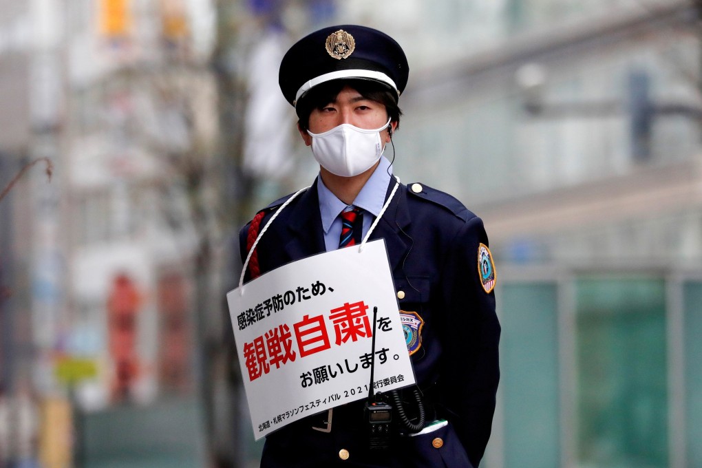 A security guard wears a sign asking members of the public to refrain from lining the route of the Hokkaido-Sapporo Marathon, a test event for the Tokyo 2020 Olympics. Photo: Reuters