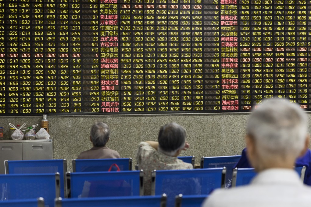 Investors sit in front of an electronic stock board at a securities brokerage in Shanghai, China. Photo: Bloomberg