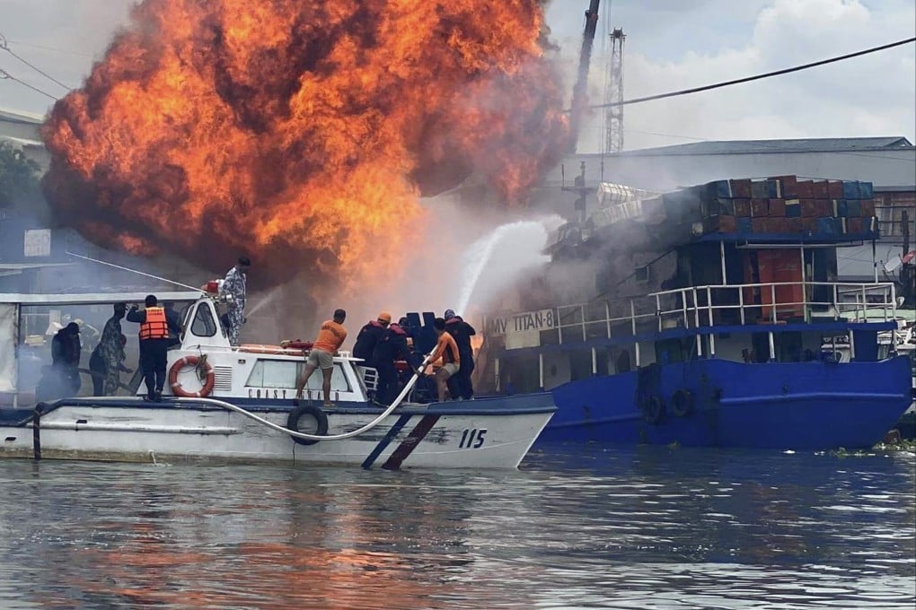 Members of the Philippine Coast Guard try to extinguish flames on a burning cargo ship docked in Manila on Saturday, June 12. Photo: AP