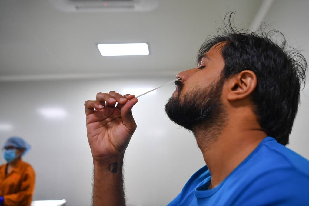 Dr Vikas Ghattargi demonstrates a Covid-19 Coviself Rapid Antigen Test self kit near Mumbai, as India battles a wave of virus infections. Photo: AFP