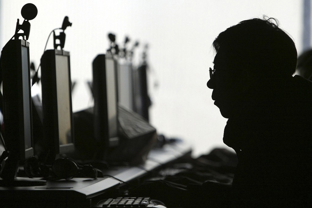 A computer user is silhouetted with a row of computer monitors at an Internet cafe in Shenyang, in northern China’s Liaoning province on January 28, 2008. Photo: AP