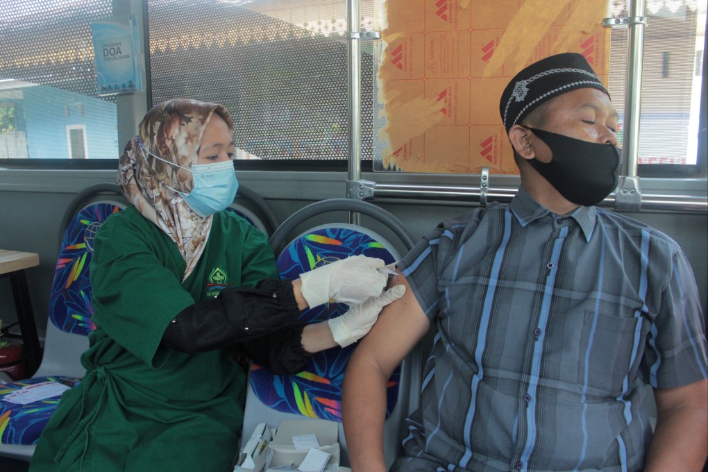 A man receives a Covid-19 shot inside a public bus which is being used as a vaccination venue, outside the Madani hospital in Pekanbaru, Riau province, Indonesia. Photo: Reuters