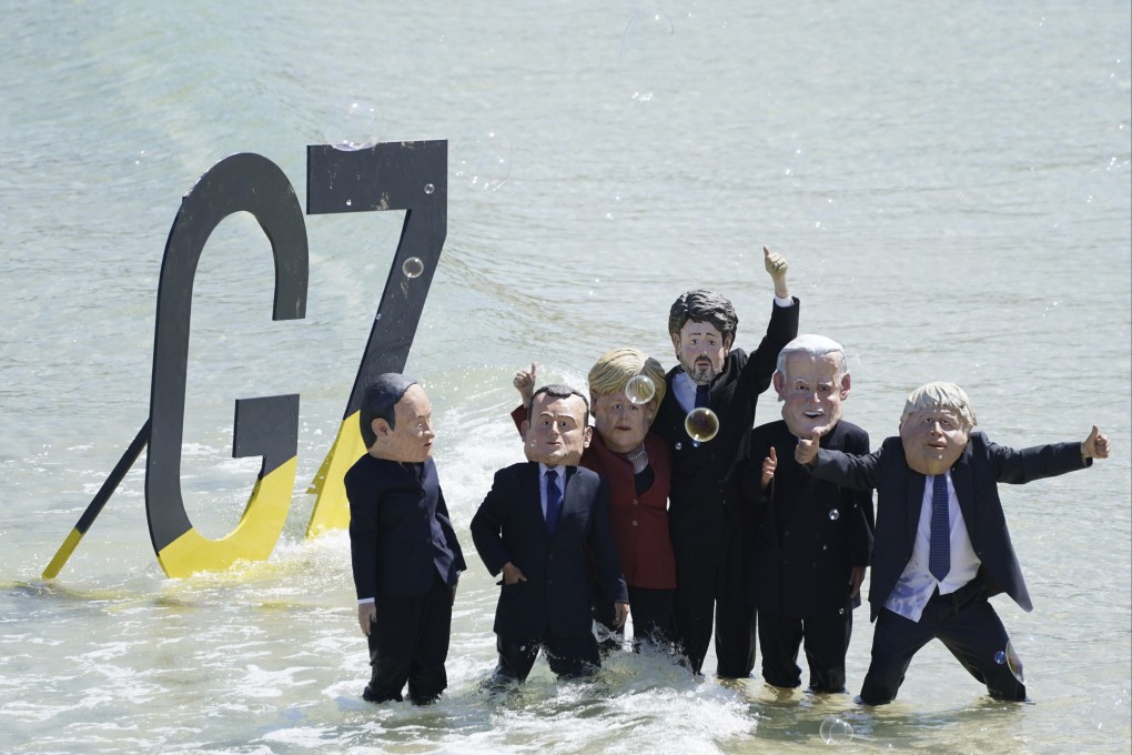 Protestors wearing masks portraying G7 leaders pose after on a beach outside the G7 meeting in St Ives, Cornwall, Britain on Sunday. Photo: AP