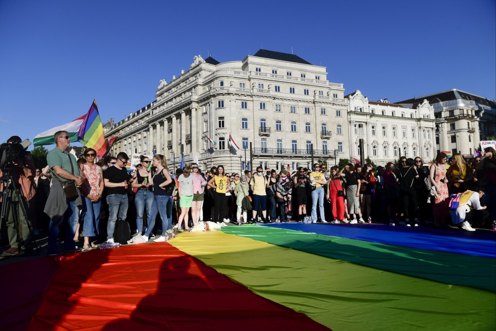 People unfurl a rainbow flag during an LGBT rights demonstration in front of the Hungarian Parliament on June 14. Photo: AP