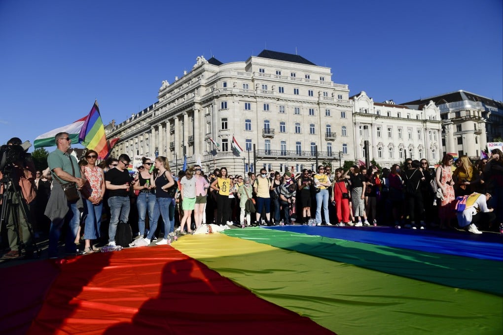 People unfurl a rainbow flag during an LGBT rights demonstration in front of the Hungarian Parliament on June 14. Photo: AP