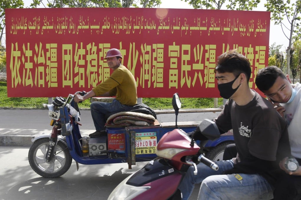 Traffic in Xinjiang passes in front of a banner calling for the stability and development of the Uyghur autonomous region. The Xinjiang government has released a summary of the 2020 census results. Photo: Kyodo