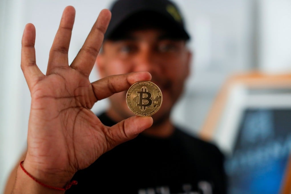 Bitcoin enthusiast Carlos Bonilla shows a physical representation of bitcoin at a Bitcoin Beach support office at El Zonte Beach in Chiltiupan, El Salvador, on June 10. Photo: Reuters