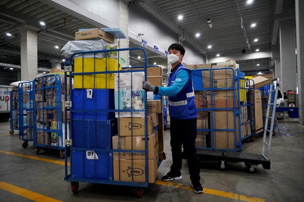 A delivery man for Coupang, Jung Im-hong  loads packages before leaving to deliver them in Incheon, South Korea. Photo: Reuters