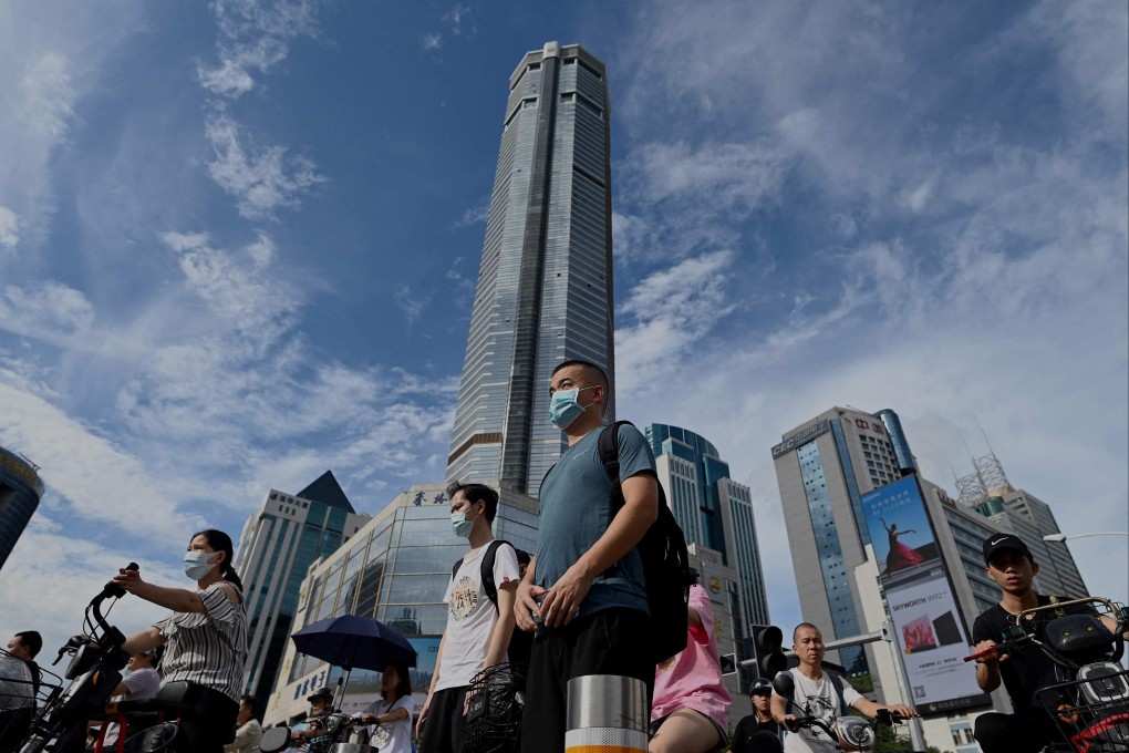 People walk past the temporarily closed 300-meter (1,000-ft.) SEG Plaza (C) in the southern Chinese city of Shenzhen in Guangdong province on May 24, 2021. Photo: AFP