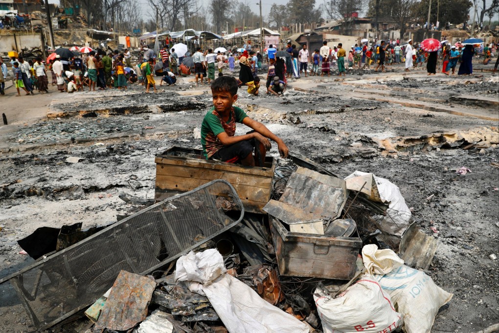 A Rohingya boy sits on a stack of burned material after a massive fire broke out and destroyed thousands of shelters in a Rohingya refugee camp in Cox’s Bazar, Bangladesh, on March 24. Photo: Reuters