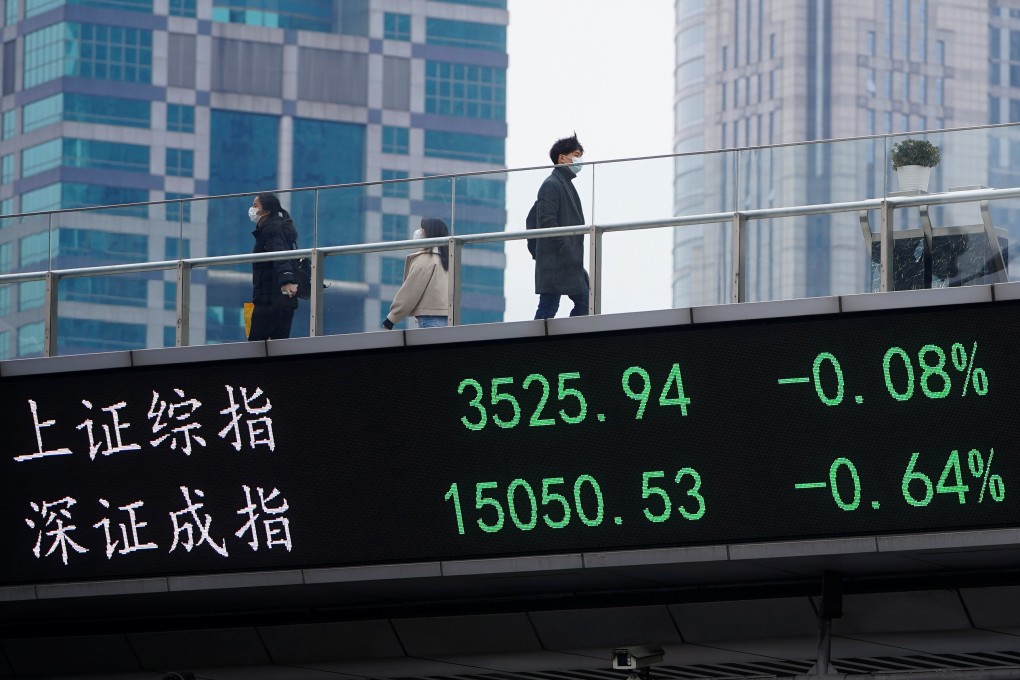 People walk past an electronic board showing the Shanghai and Shenzhen stock indices, in Shanghai’s Lujiazui financial district. Photo: Reuters