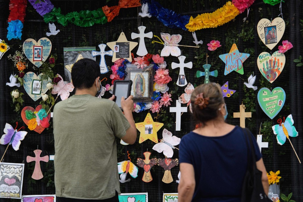 People look at the “Naming the Lost Memorials” installation to remember the lives lost due to the coronavirus pandemic, at a cemetery in New York. Photo: AFP