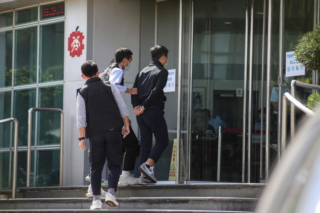 Apple Daily editor-in-chief Ryan Law, in handcuffs, is escorted into the tabloid’s offices by national security police on Thursday morning. Photo: Winson Wong