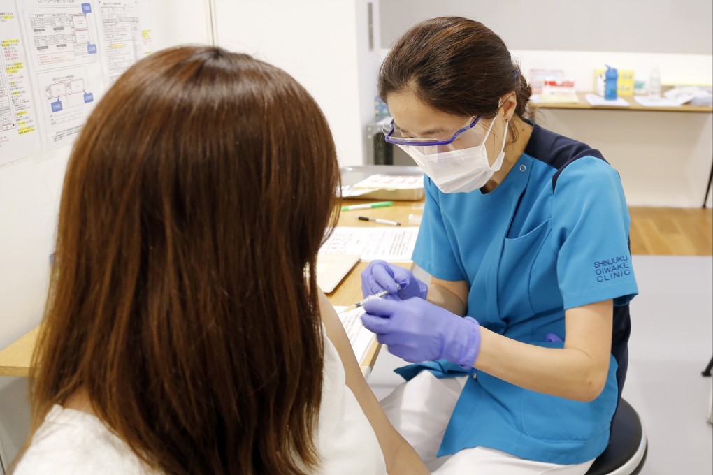 A Japanese medical worker administers a Covid-19 vaccine. Photo: AP