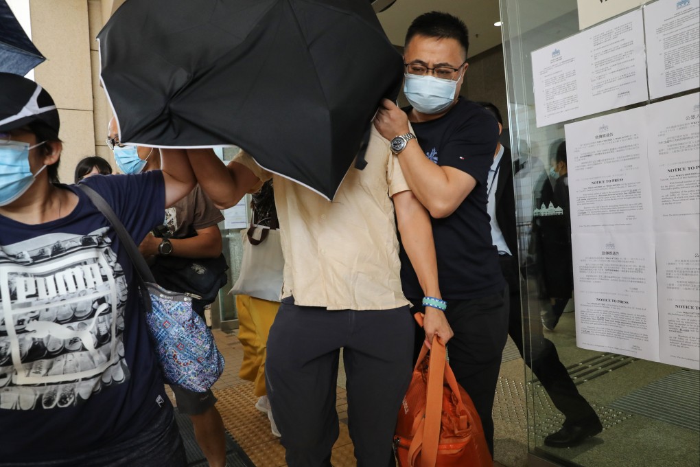 Ta Kung Pao reporter Wong Wai-keung is shielded from cameras as he leaves West Kowloon Court on Thursday. Photo: Edmond So