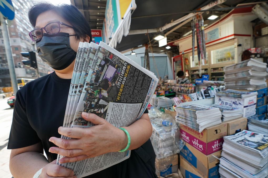 Customers snap up multiple copies of Friday’s Apple Daily on the morning after five of its senior executives were arrested. Photo: Felix Wong