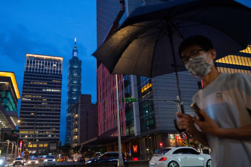 A pedestrian with an umbrella passes in front of Taipei 101 tower in Taipei, Taiwan. Photo: Bloomberg