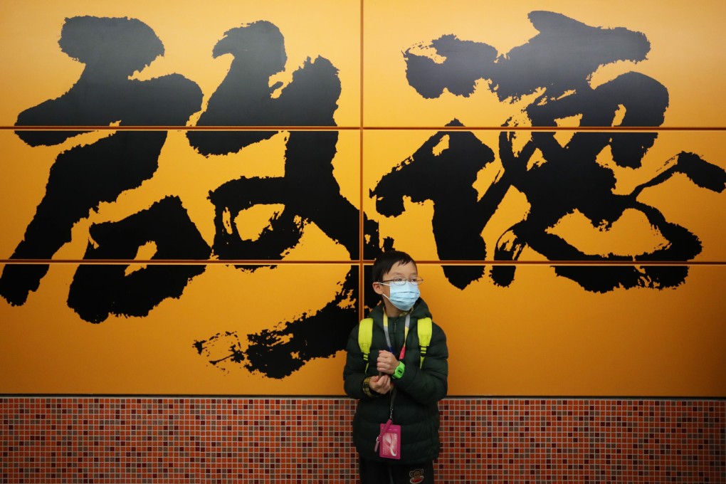 A young passenger at the new Kai Tak MTR station stands against a wall that is splashed with Abe Au’s calligraphic work depicting the area’s name. Photo: Winson Wong
