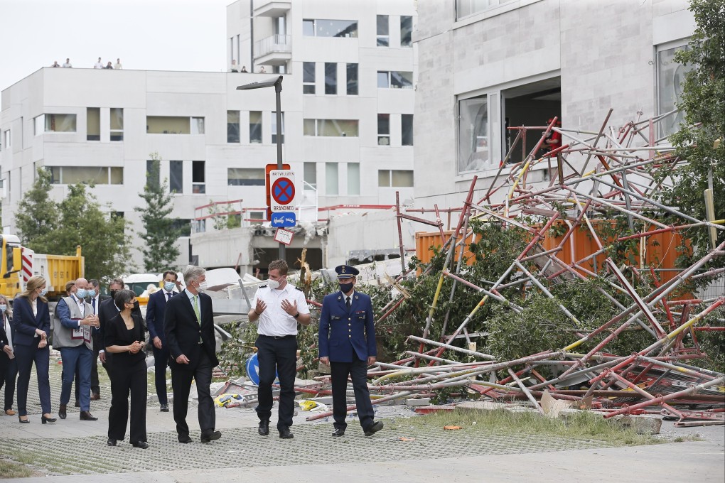 King Philippe of Belgium, centre left, visits the site of a building that partially collapsed in Antwerp, Belgium on Saturday. Photo: EPA-EFE
