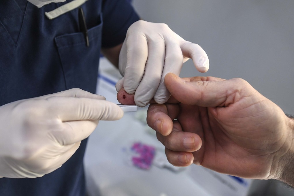 A medical worker handles an antibody rapid serological test for COVID-19 following a finger prick blood sample. Photo: Getty Images