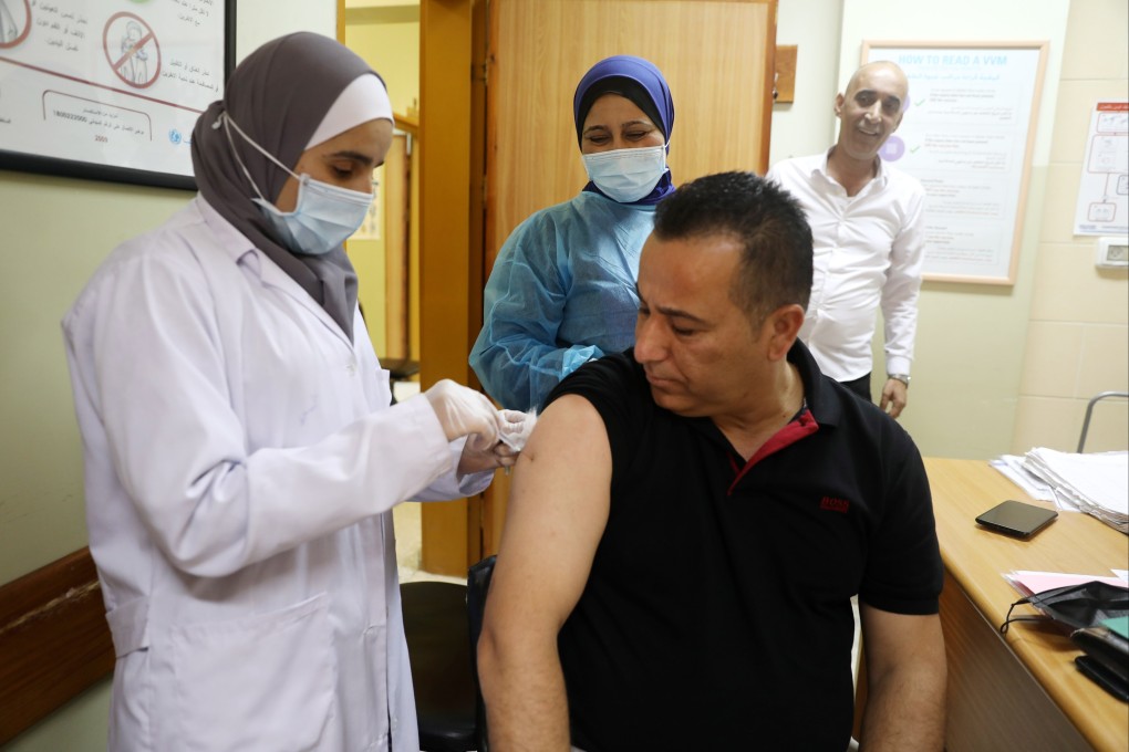 A Palestinian medical worker receives the Pfizer-BioNTech vaccine at the Palestinian Medical Centre in the West Bank city of Dura. Photo: EPA-EFE