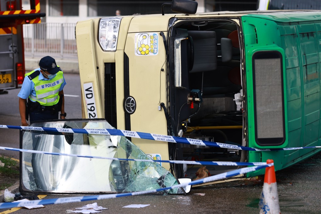 A police officer inspects a minibus flipped on its side following a collision with a car near the junction of Sha Tin Wai Road and Tai Chung Kiu Road on June 13. The 57-year-old minibus driver died while six passengers and the car driver were injured in the accident. Photo: May Tse