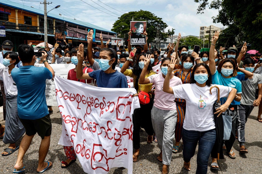Protesters display the three-fingered salute while marking civilian leader Aung San Suu Kyi’s birthday. Photo: AFP