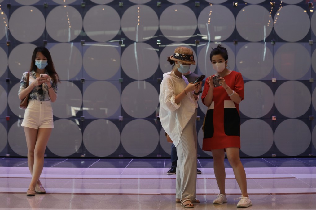 People use their mobile phones in Wan Chai in May. As more people sign up online for lucky draws tied to Covid-19 vaccination, data privacy is a concern. Photo: Xiaomei Chen