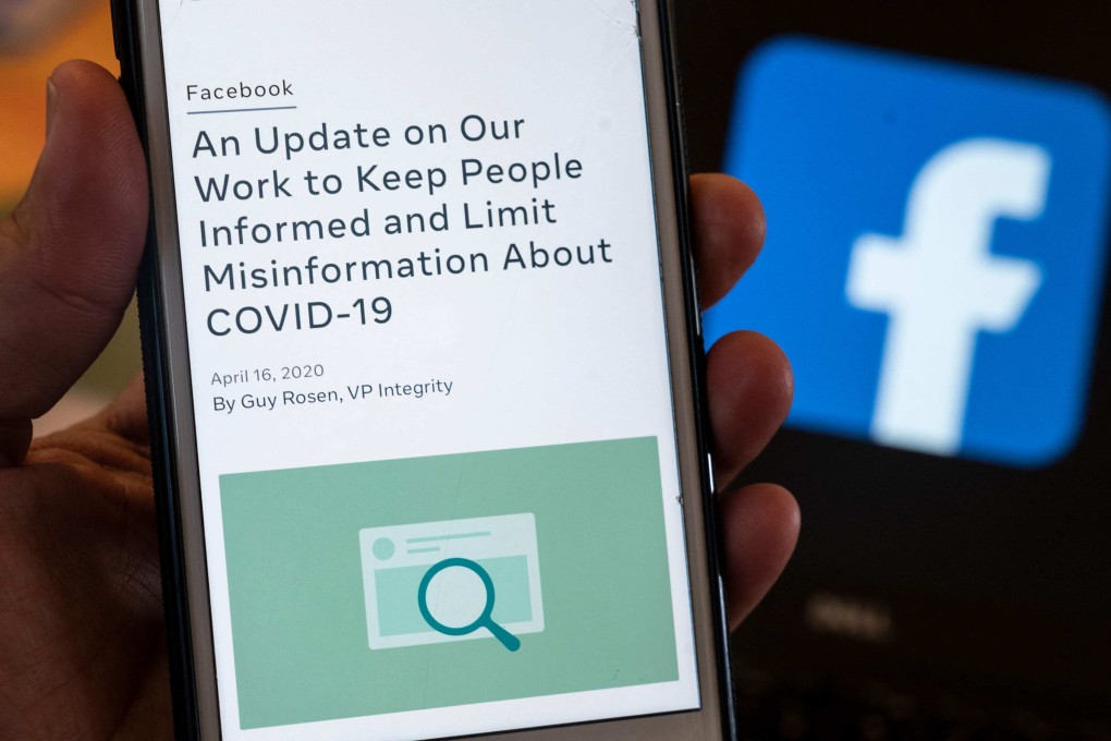 A smart phone screen displays a new policy on Covid-19 misinformation with a Facebook website in the background. Facebook is one of the digital platforms that have adopted the Australian Code of Practice on Disinformation and Misinformation. Such voluntary codes are an essential tool in fighting fake news. Photo: AFP