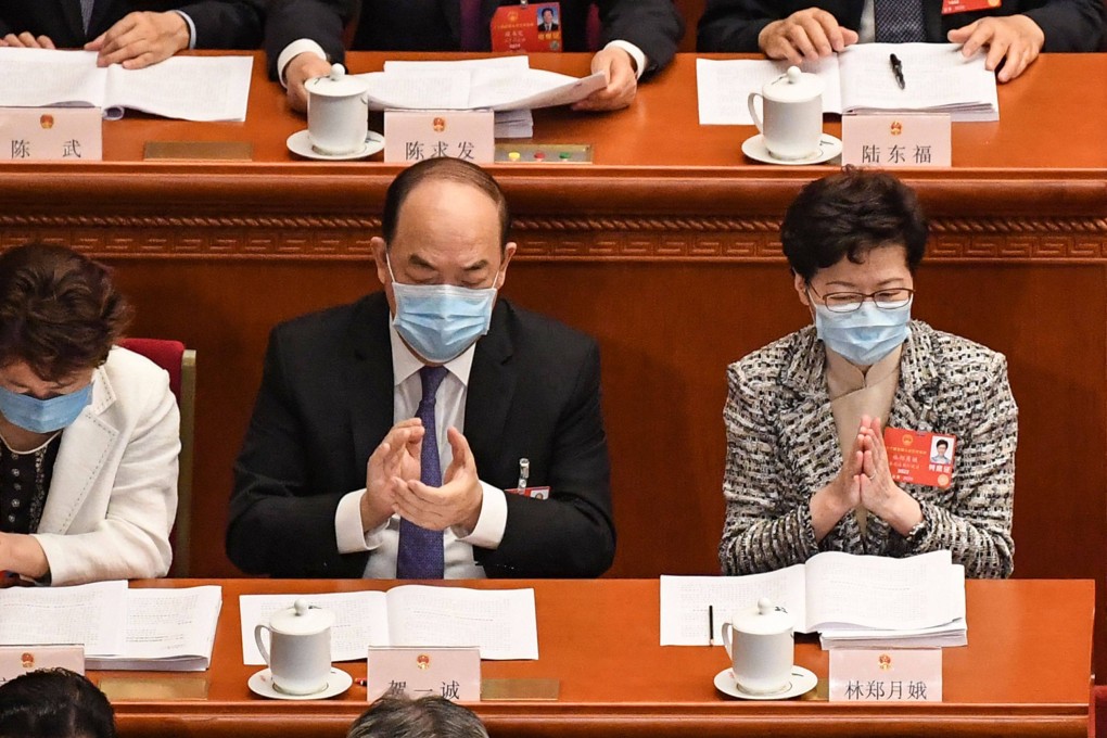 Macau Chief Executive Ho Iat-seng (centre) and Hong Kong Chief Executive Carrie Lam (right) attend the opening session of the National People’s Congress in Beijing on May 22, 2020. Photo: AFP