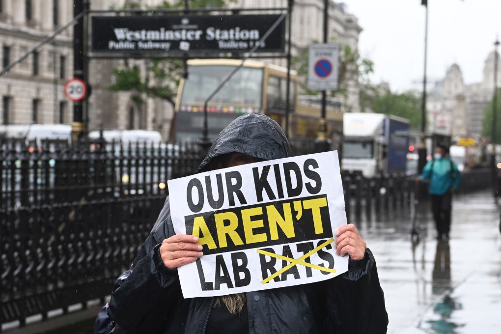 An anti-lockdown demonstrator holds a placard during a rally in Westminster in London on June 21, as the UK government delayed a full reopening for a further four weeks, due to a significant rise in Delta variant of Covid-19 cases across England.Photo: EPA-EFE