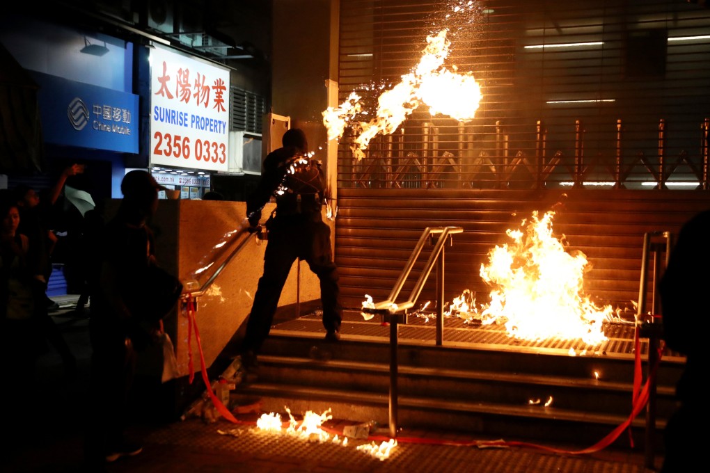 A Hong Kong protester throws a petrol bomb at an MTR station on December 1, 2019. Photo: Reuters
