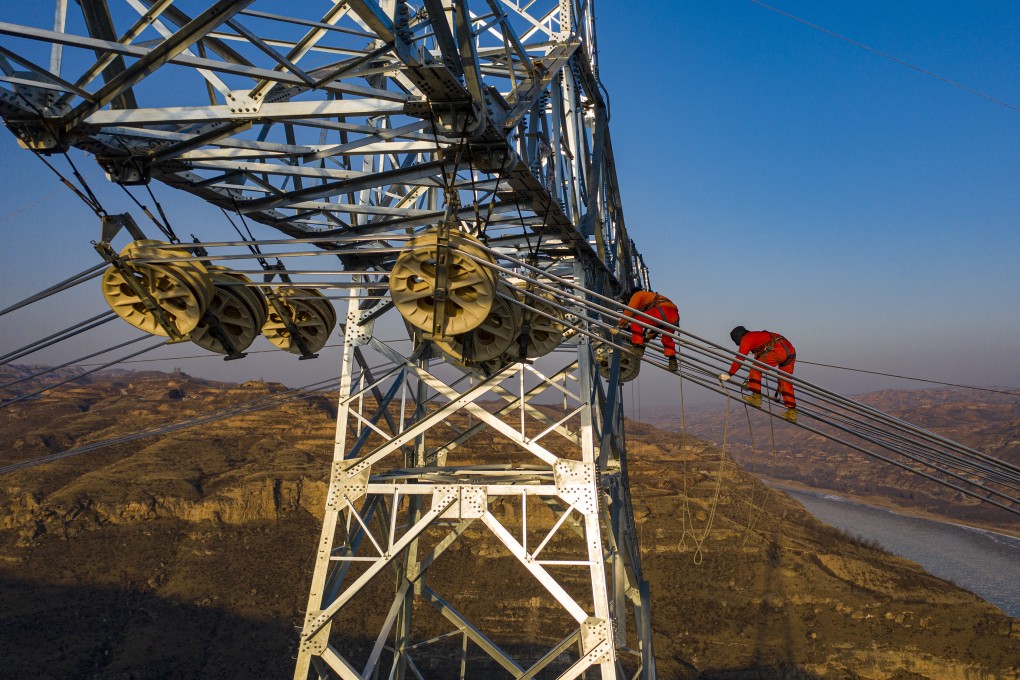 Electricians install electric wires on a transmission tower on the banks of China’s Yellow River during construction of an 800-kilovolt ultra-high voltage (UHV) power line on December 20, 2020 in Qingjian County, Shaanxi province, China. Photo: VCG via Getty Images
