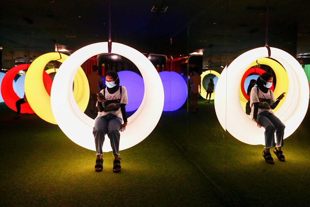 A woman sits on an art installation at Trans Studio in Jakarta, Indonesia. Photo: Reuters