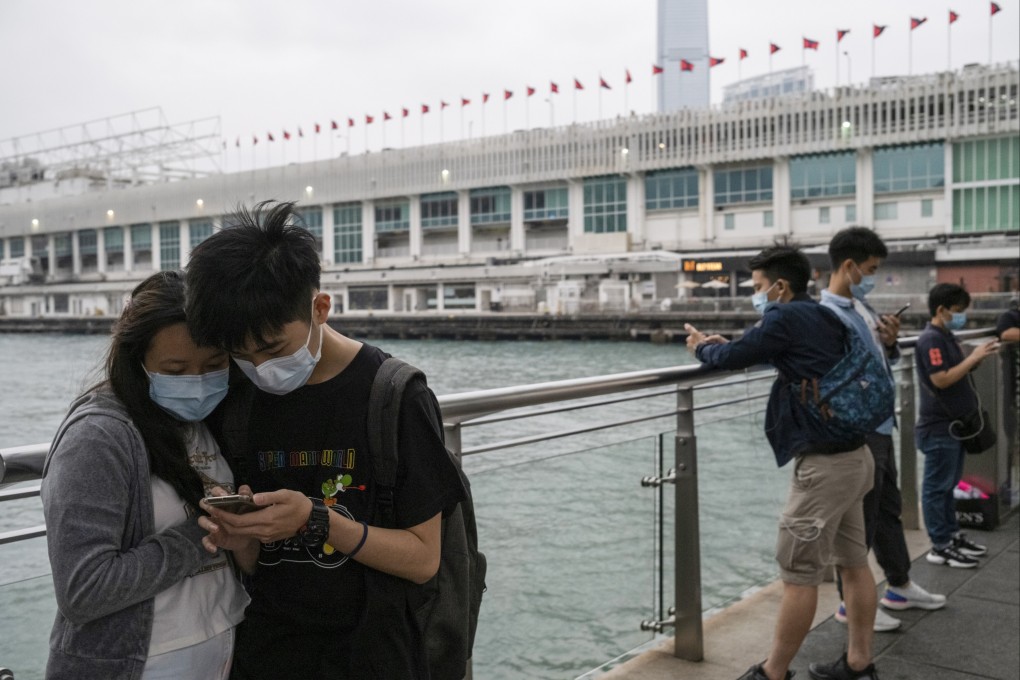People look at their mobile phones at the Tsim Sha Tsui harbourfront on April 5. Photo: Sun Yeung
