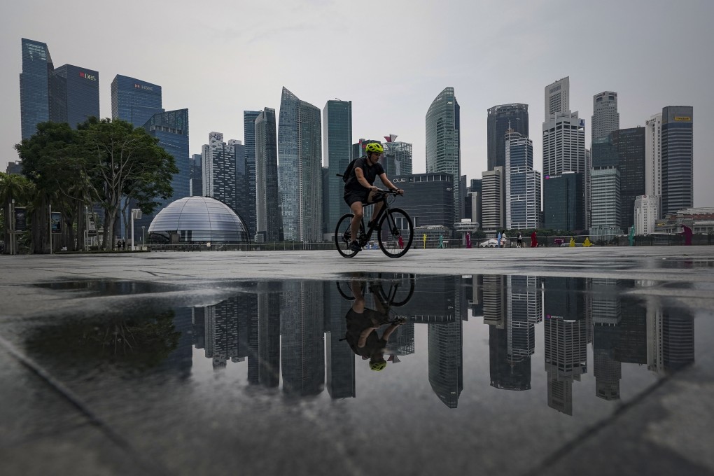 Singapore’s financial district across the Marina Bay forms the backdrop as a cyclist rides along on July 6. Photo: EPA-EFE