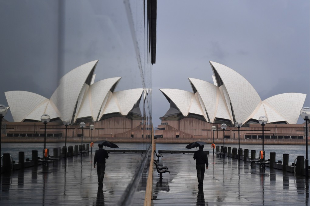 A pedestrian walks past the Sydney Opera House in Sydney. Singapore’s decision to live with the coronavirus will put pressure on other zero-Covid economies to do the same. Photo: EPA