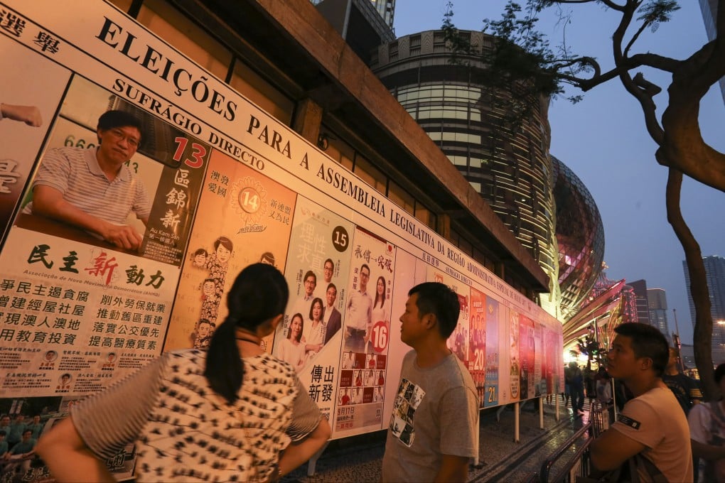 Macau residents look at posters for the 2017 Legislative Assembly Election on September 17 that year. Incumbent lawmakers are among some 20 pro-democracy candidates disqualified from the 2021 race. Photo: Dickson Lee