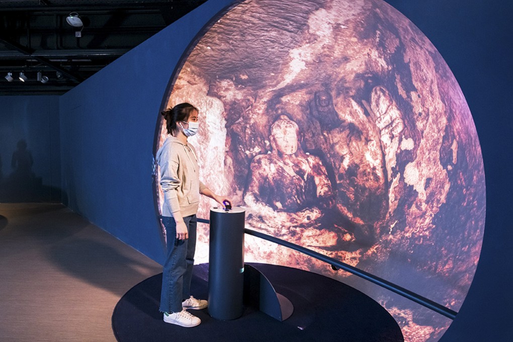 A visitor uses a control stick to navigate a spherical projection of a Buddhist rock-cut cave in India at the “Atlas of Maritime Buddhism” exhibition, City University of Hong Kong. Photo: The Atlas of Maritime Buddhism Research Project