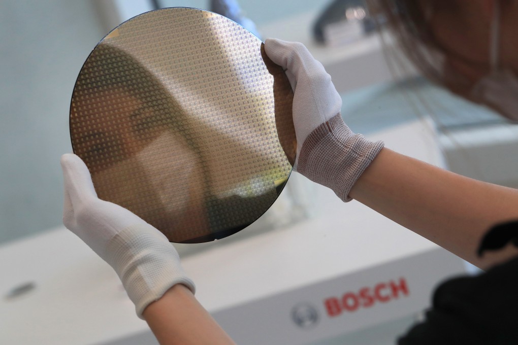 A worker holds a 200mm silicon wafer at the semiconductor fabrication plant operated by Robert Bosch in Dresden, Germany. Photo: Bloomberg