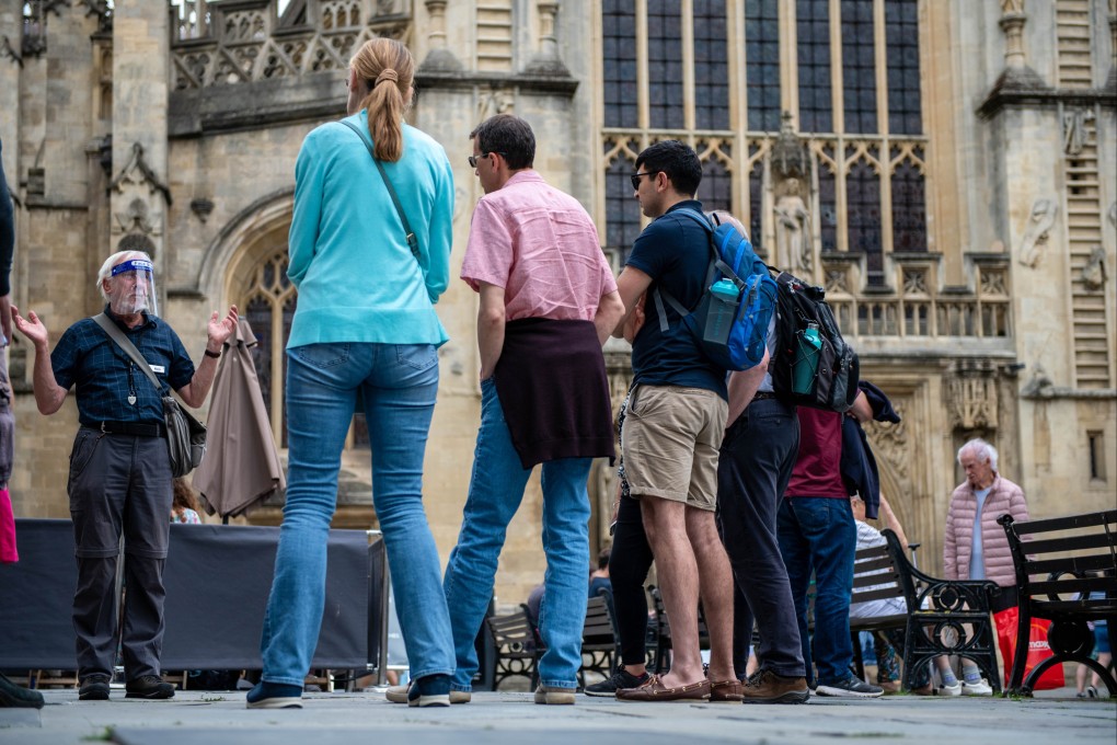 A tour guide wearing a face shield speaks to a group outside Bath Abbey in the UK, on July 5. The Delta variant is spreading, even in countries with high vaccination rates like Britain. Photo: Bloomberg