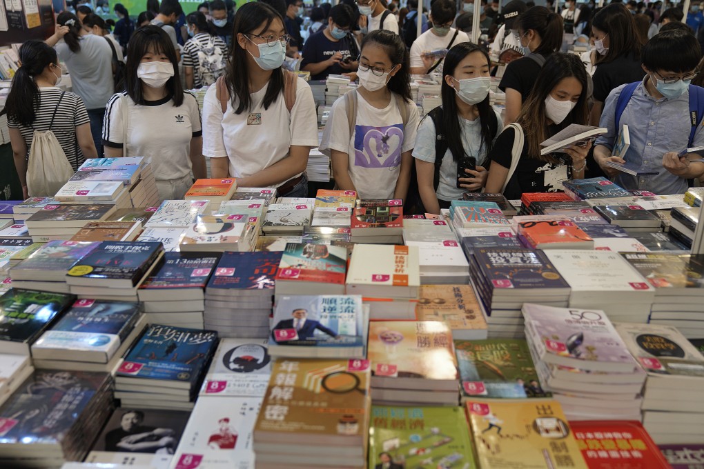 People browse at the Hong Kong book fair on July 14. The fair was postponed twice last year due to the coronavirus pandemic. Unless vaccination rates go up, Hongkongers can expect no reprieve from the current travel and social distancing restrictions. Photo: AP