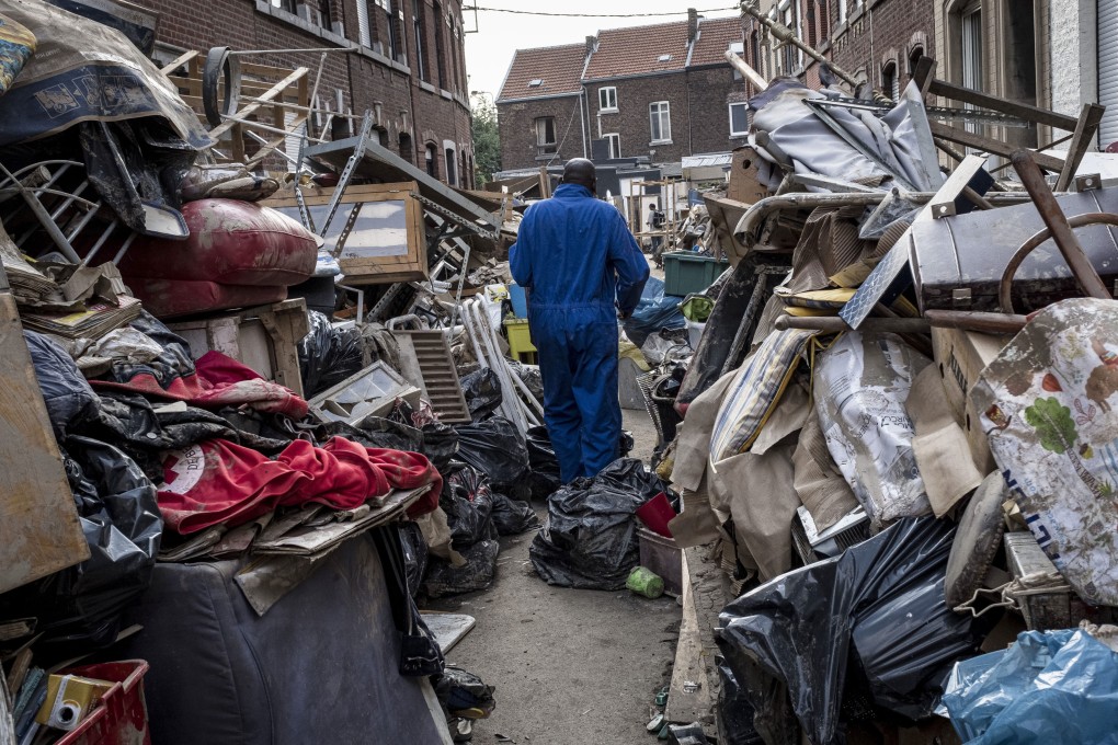 A man walks through piles of damaged and discarded household items after flooding in Liege, Belgium, on July 19. Skittish markets have been further unnerved by the loss of life and economic dislocation caused by extreme weather events from the US and Europe to China. Photo: AP