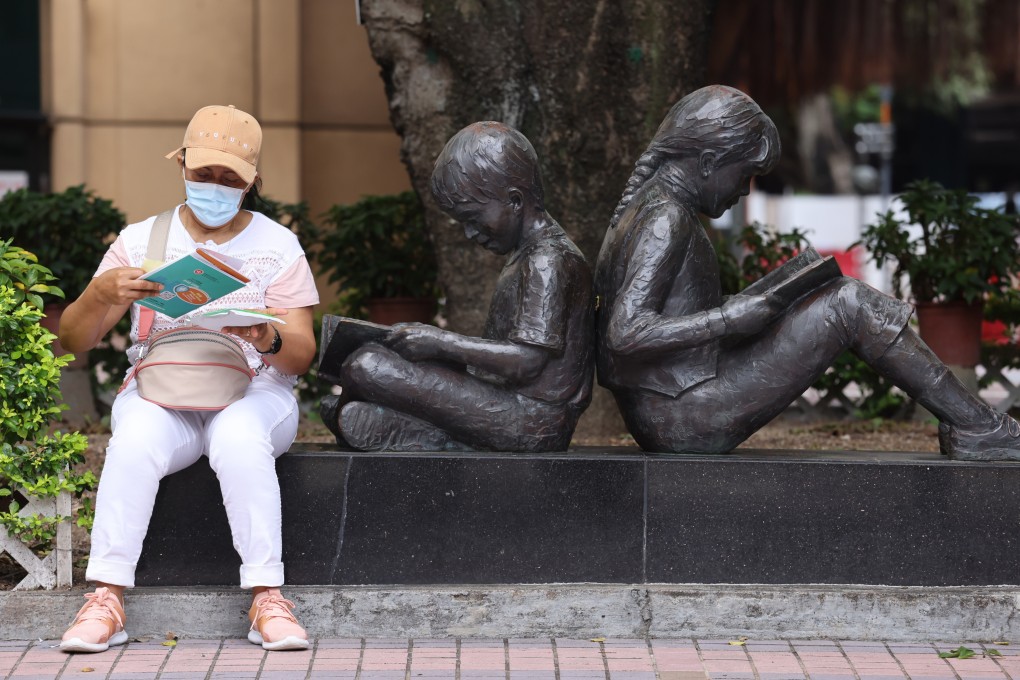 A woman reads a vaccination pamphlet outside the Hong Kong Central Library in Causeway Bay on June 19. Photo: Nora Tam