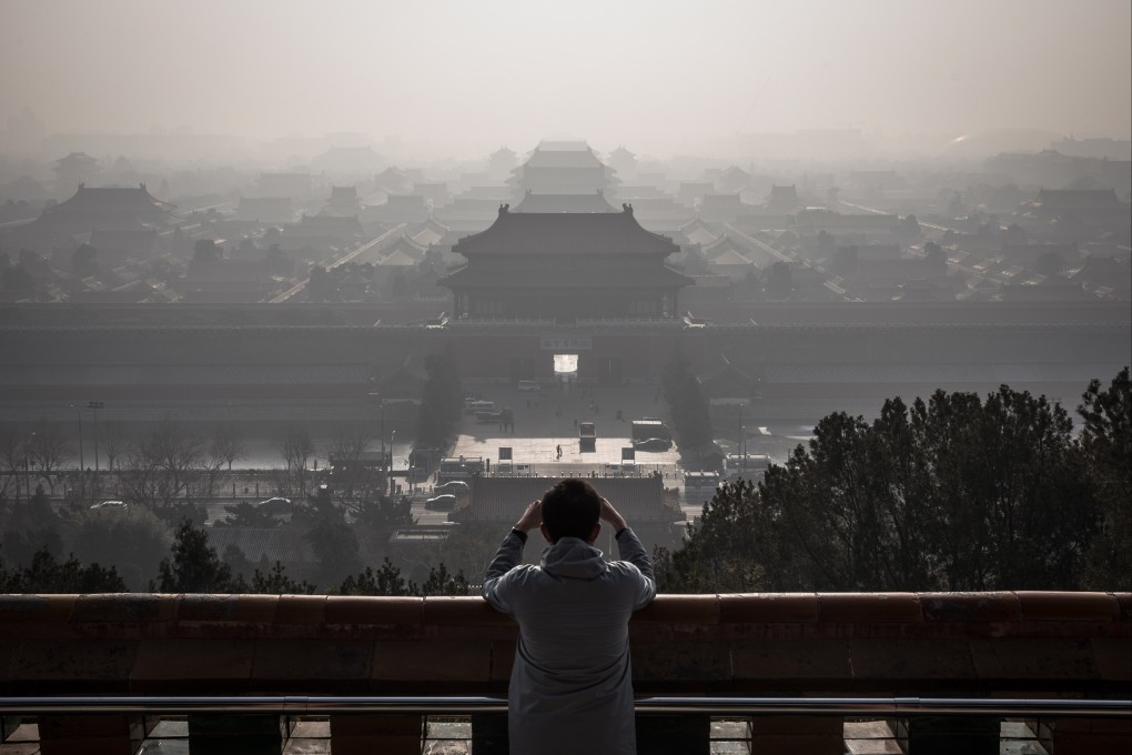 A man takes photos of the Forbidden City as thick haze engulfs Beijing on December 9, 2019. China has committed to being carbon neutral by 2060. Photo: EPA-EFE