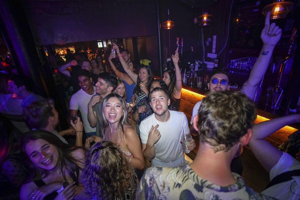 Revellers in London react on the dance floor shortly after the reopening at midnight on July 19. Thousands of young people danced the night away at “Freedom Day” parties as almost all coronavirus restrictions in England were scrapped. Nightclubs had been closed since March 2020. Photo: AP