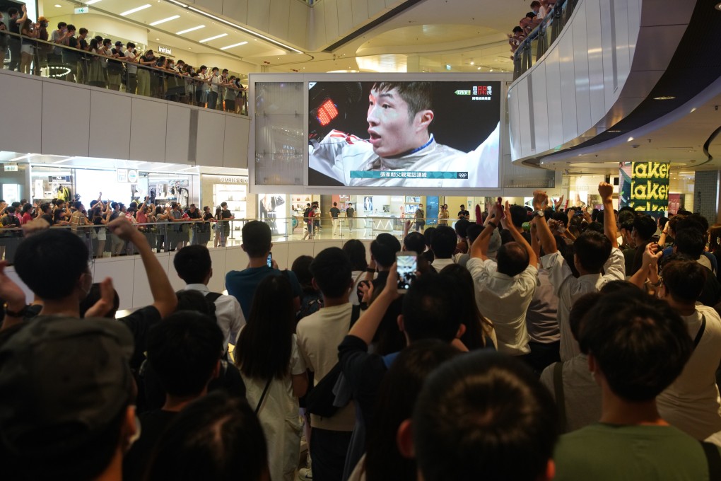 Hong Kong fans watching on a giant screen at a shopping mall cheer Edgar Cheung’s victory against Garozzo Daniele of Italy in the men’s individual foil finals in fencing at the Tokyo Olympic Games on July 26. Photo: Winson Wong