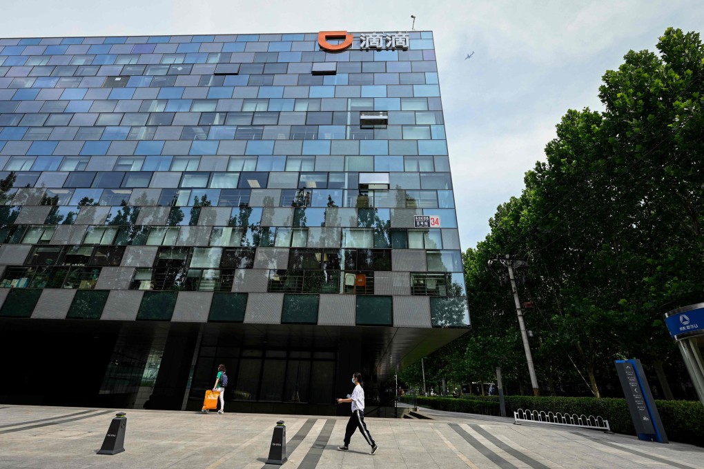 People walk past the headquarters of Didi Chuxing in Beijing on July 2. The “Didi effect” – the fallout from Beijing’s launch of a data security probe against the ride-hailing group just days after its initial public offering in New York – has wreaked havoc with China-sensitive assets. Photo: AFP