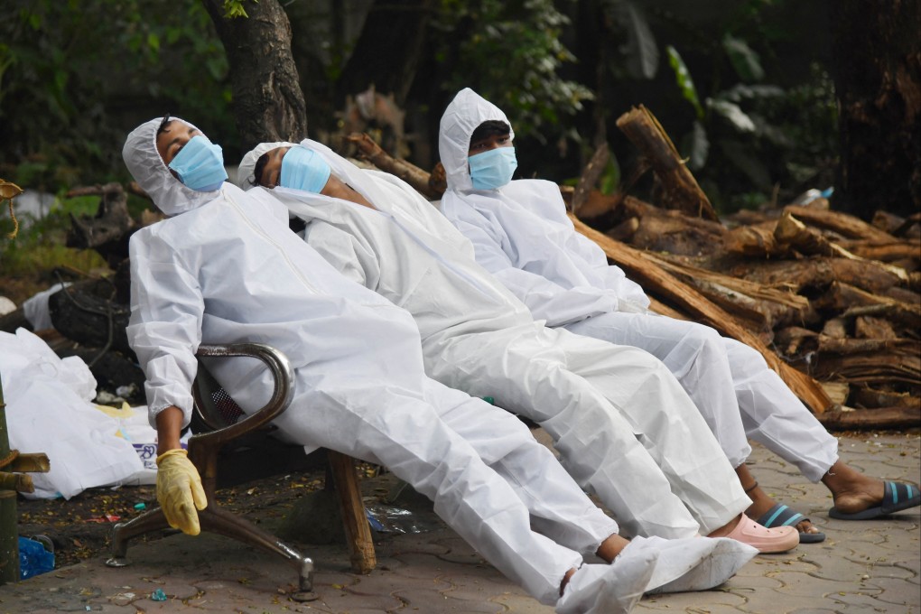 Ambulance staff rest after working at a crematorium ground in India on June 25, 2021. Covid-19 remains a threat in India, with more than 30 million people infected and over 400,000 deaths, though many believe these figures are far below the real numbers. Photo: AFP